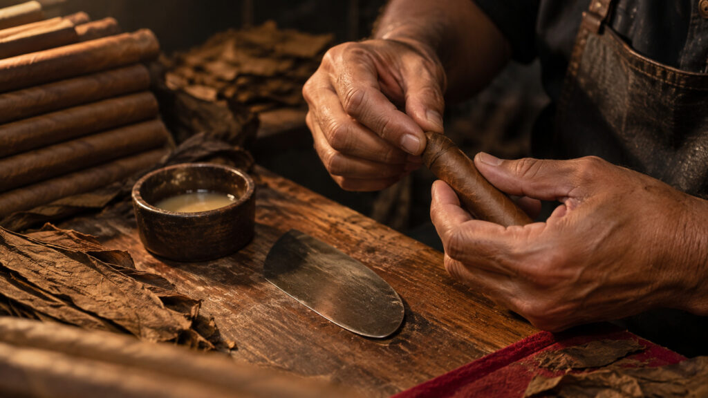 Master roller's hands finishing a cap at a bench, the answer to counterfeit cigars